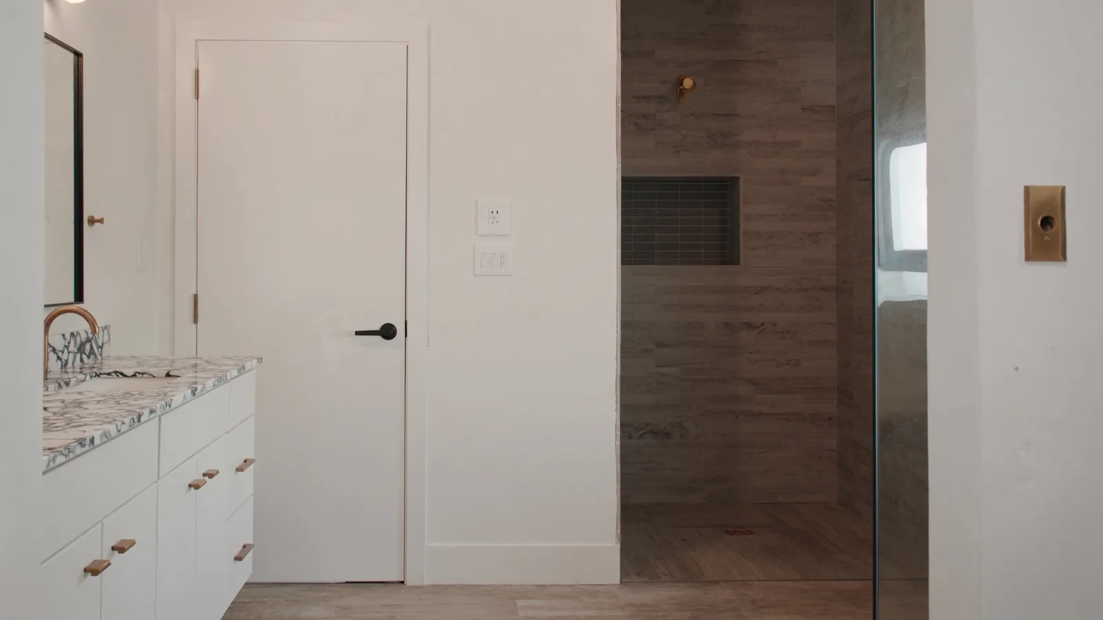The same bathroom after remodel — deep soaking tub retained, walk-in shower addition, subway tile walls, and matte black fixtures