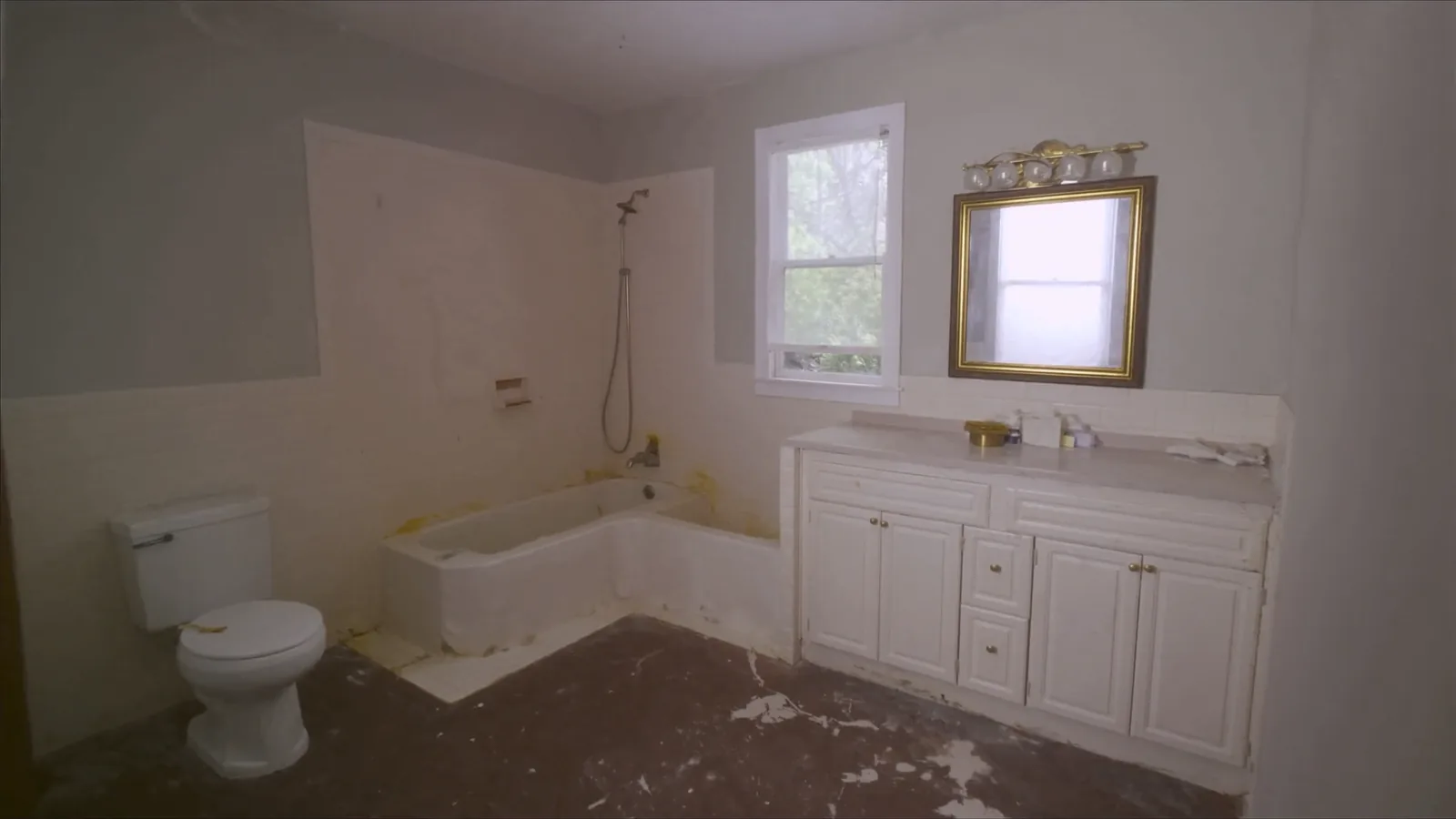 Dated 1980s Bellevue bathroom before remodel — original tub surround with failing grout and worn builder-grade vanity