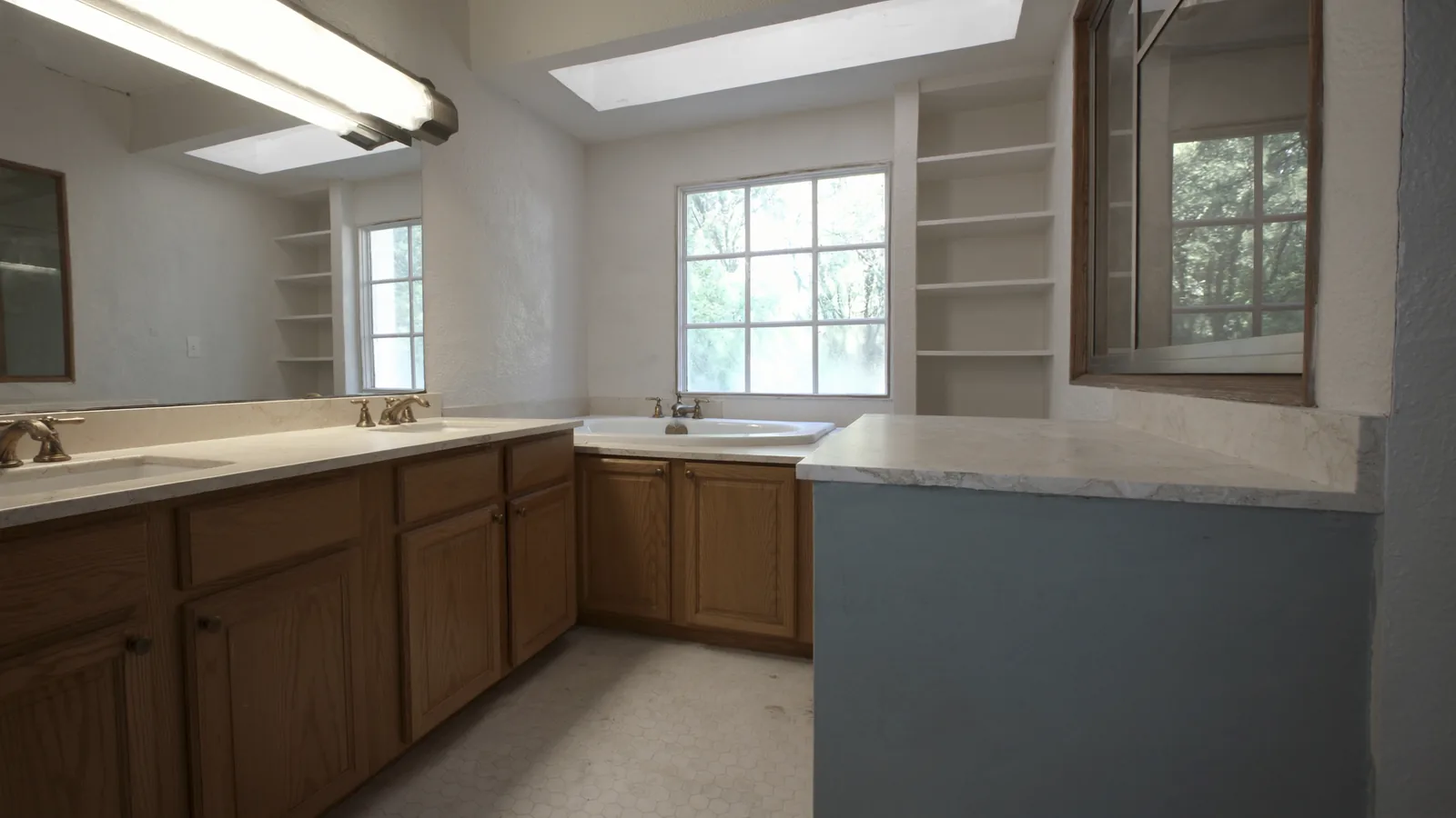 Dated Everett bathroom before remodel — original porcelain tile, worn vanity cabinet, outdated lighting